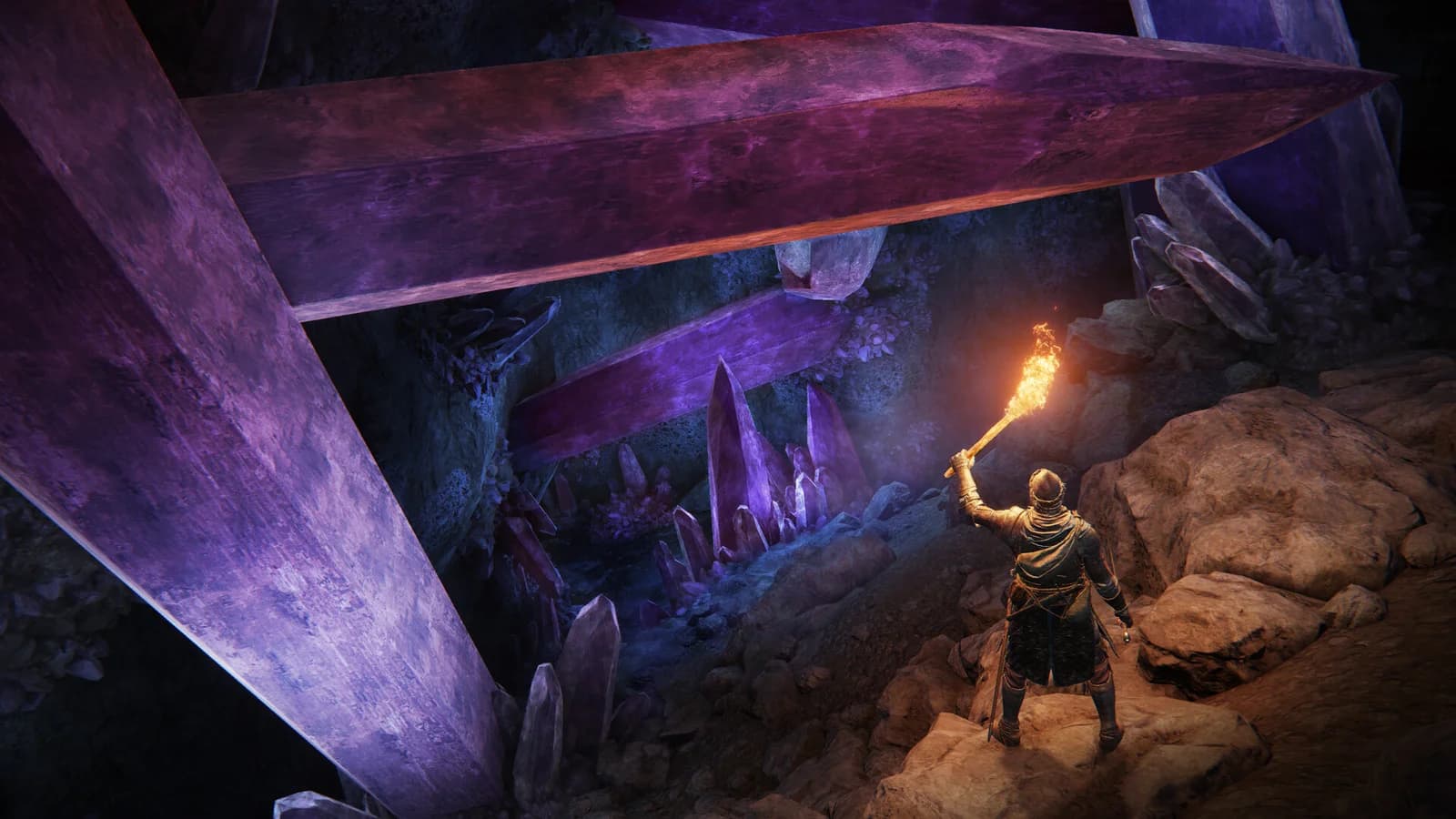 A Tarnished holds a torch above a descending cave path among large purple crystals in Elden Ring.