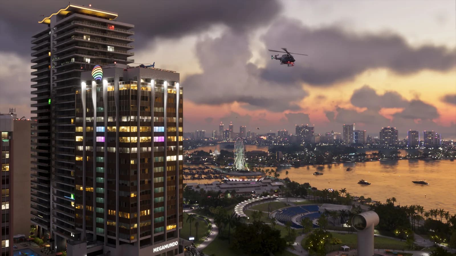 Official Vice City screenshot showing a lit waterfront tower, a helicopter, a Ferris wheel, boats and distant buildings under evening clouds.